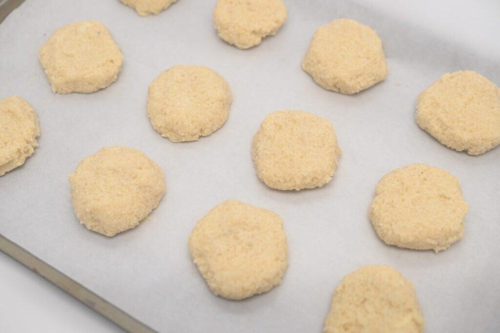 Keto Italian lemon cookie dough shaped on a parchment-lined baking sheet before baking.