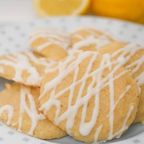 Keto Italian lemon cookies with sugar-free lemon glaze served on a plate with fresh lemons.