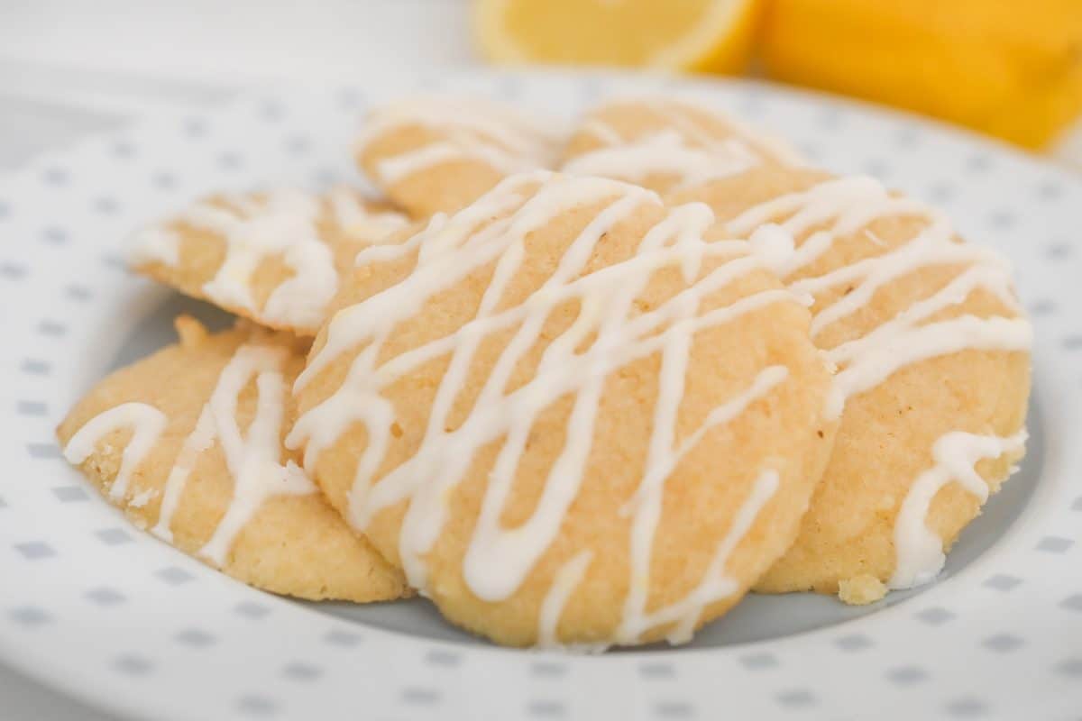 Keto Italian lemon cookies with sugar-free lemon glaze served on a plate with fresh lemons.